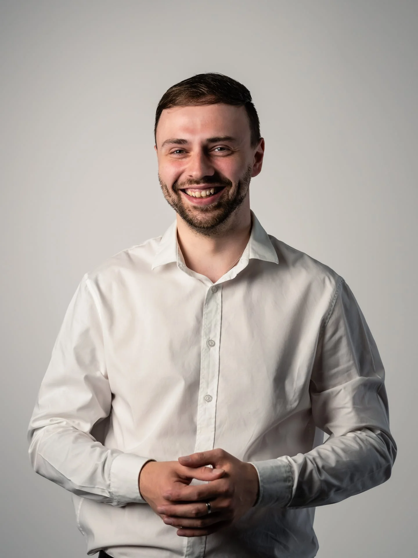 Max Mudder, Beratung und Vertrieb bei medacom, lachender junger Mann mit Bart in weißem Hemd